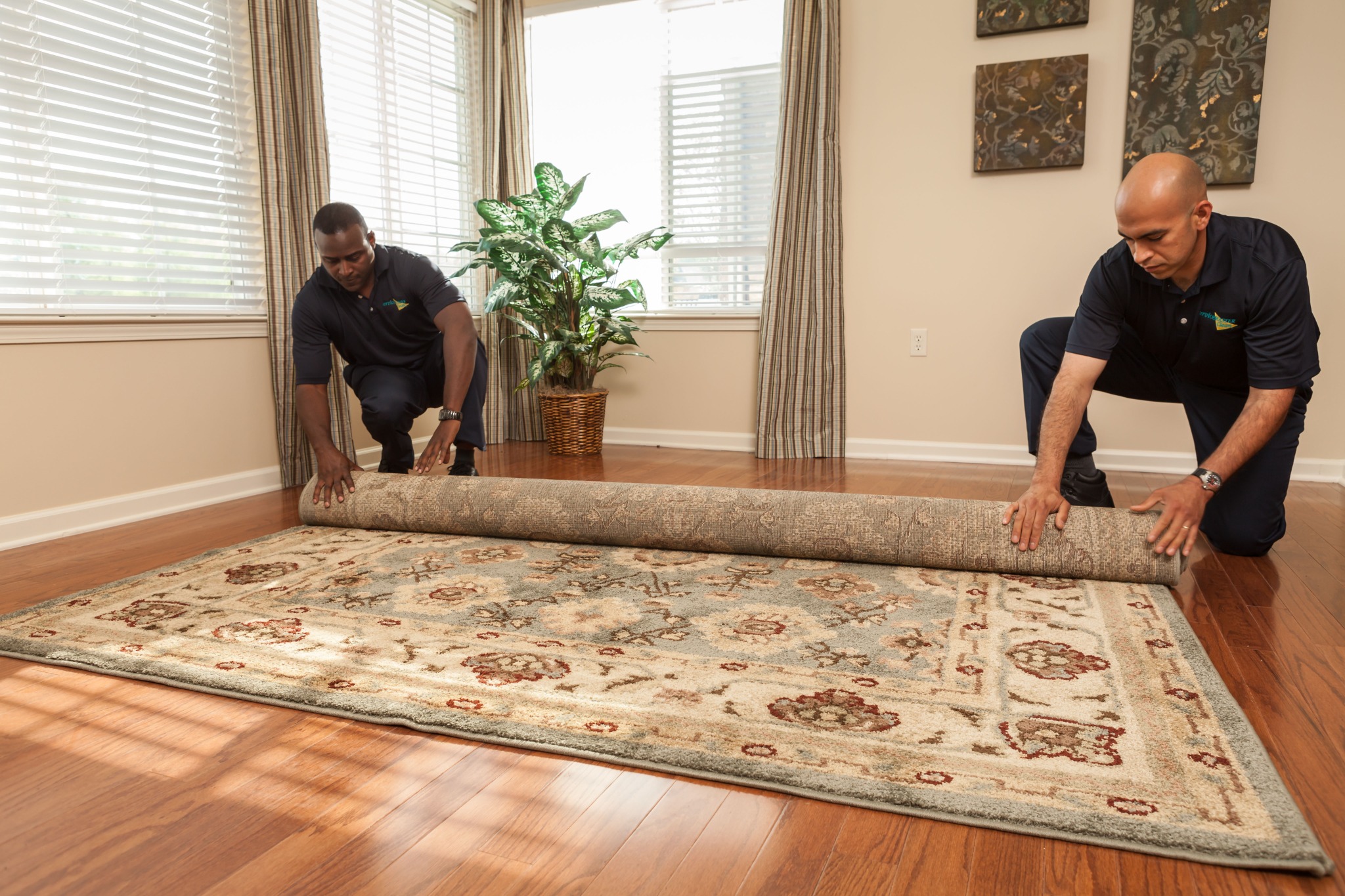 ServiceMaster technicians rolling an area rug
