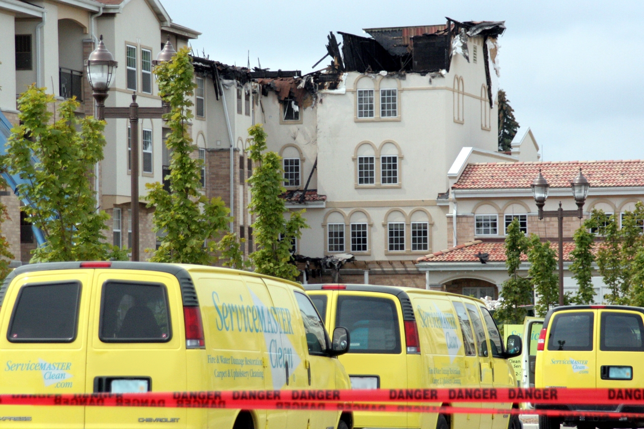 ServiceMaster vans outside a building with extensive fire damage
