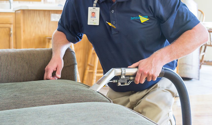 ServiceMaster technician cleaning an upholstered chair