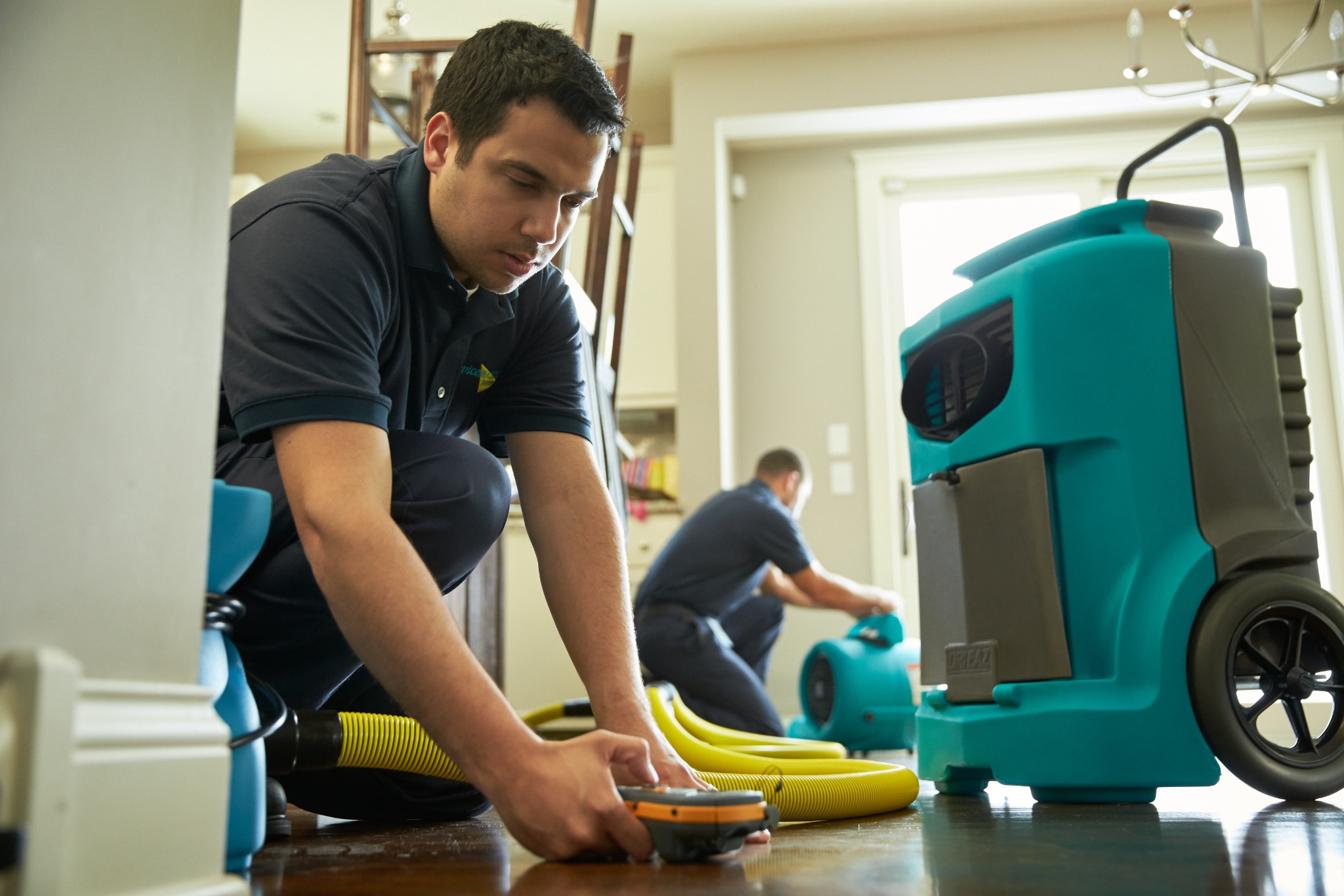 Water damage technician checking moisture and drying equipment